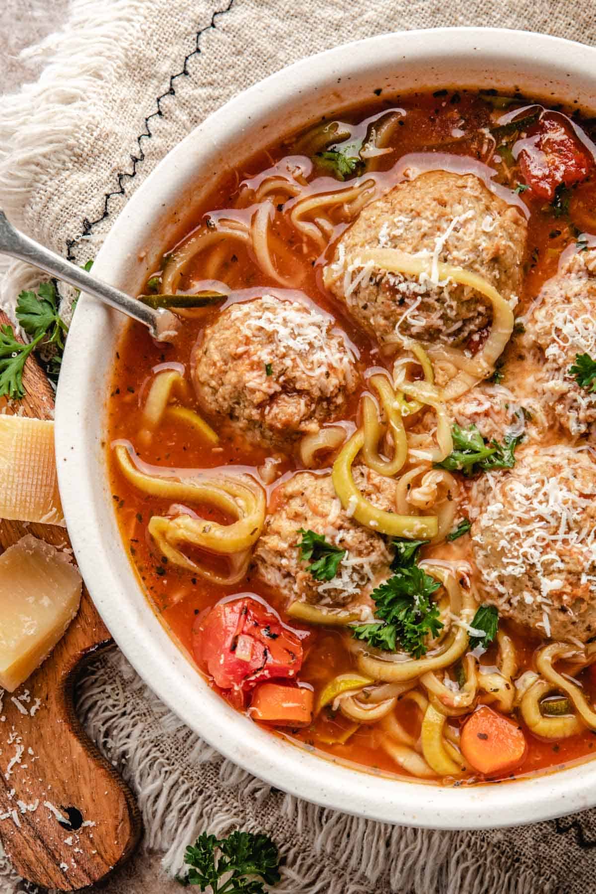 a closeup of italian meatball soup with a rich tomato broth 