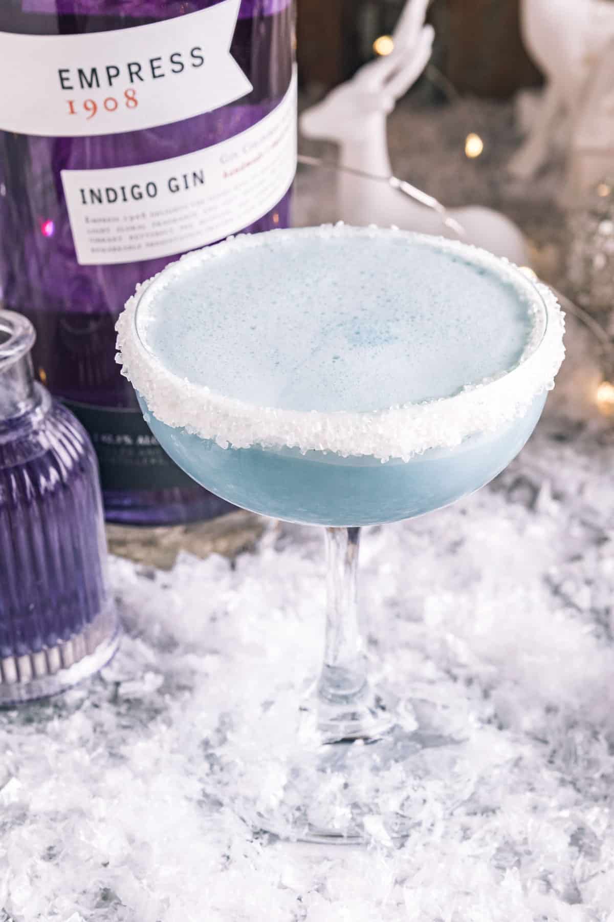 an upclose shot of a jack frost cocktail with empress gin behind it