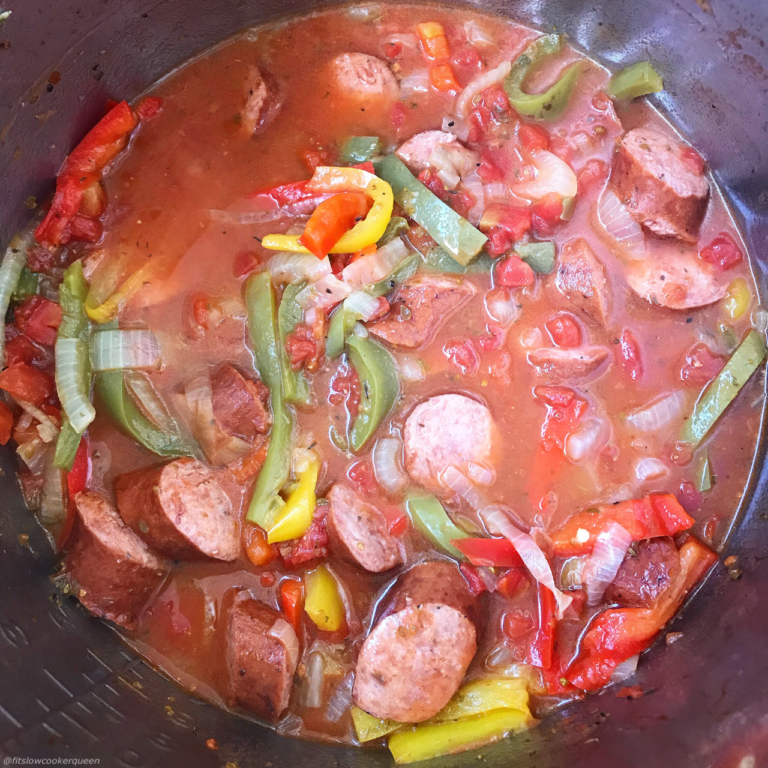 a crockpot filled with sausage, bell pepper, and onions. 