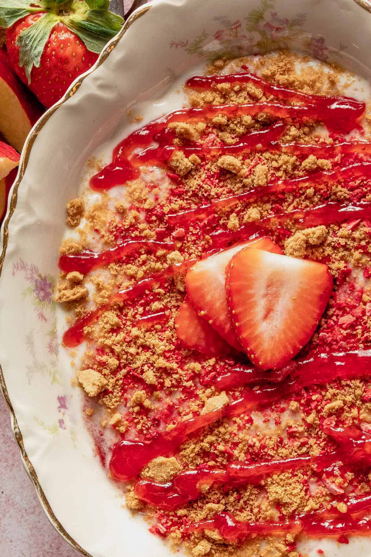 an up close photo of strawberry dip with fresh strawberry slices on top.