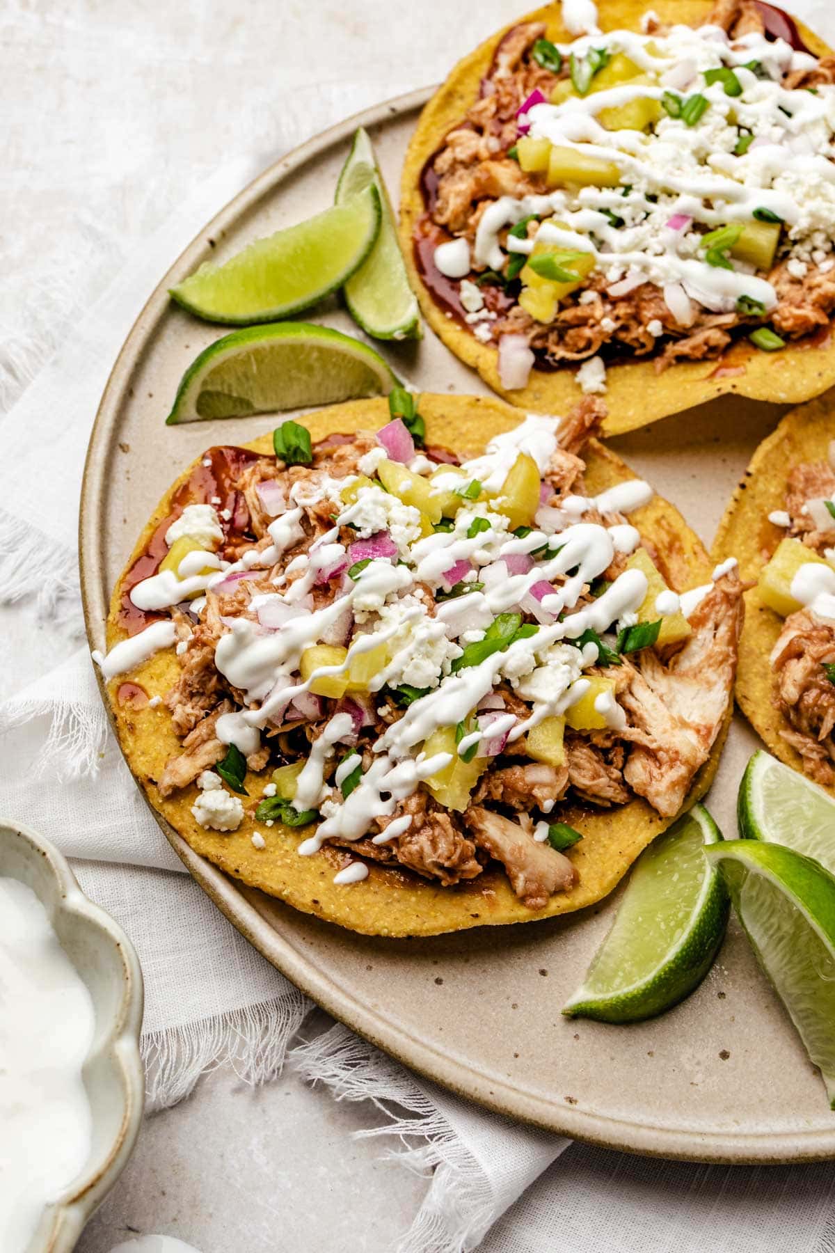 three chicken tostadas on a plate next time wedges of lime