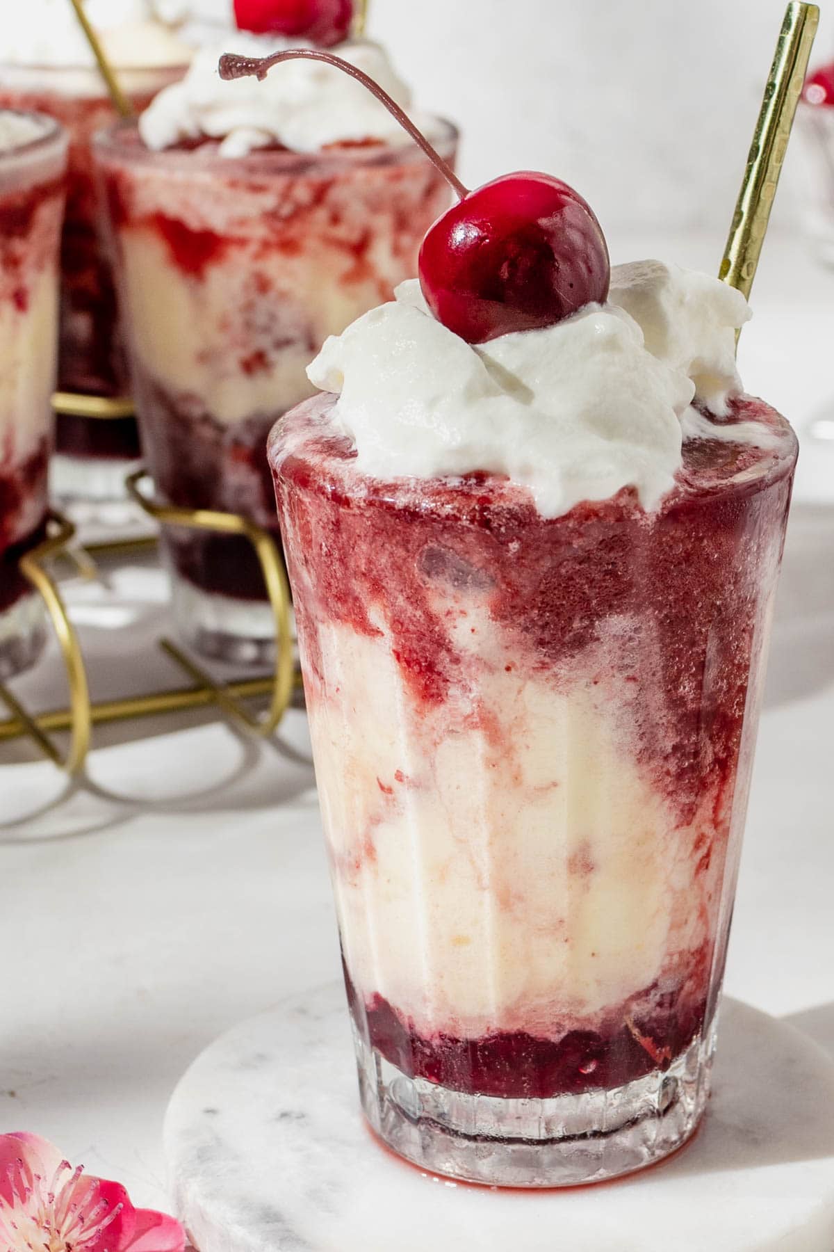 a creamy cocktail topped with whipped cream and a cherry. 