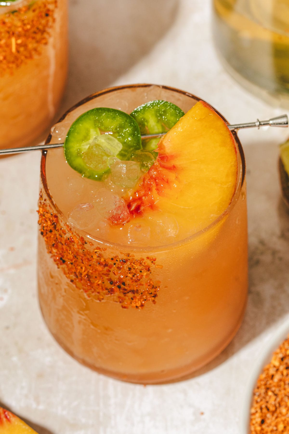 a margarita mocktail in a tall glasswith ice and garnished with jalapenos