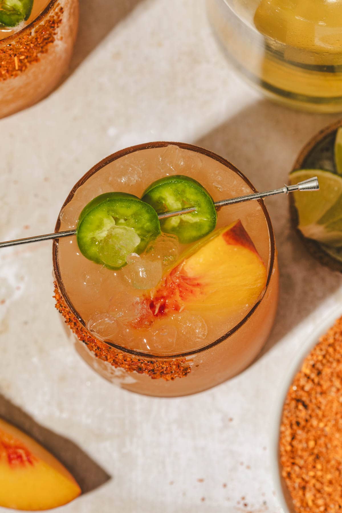 overhead shot of a margarita mocktail topped with peaches and jalapenos