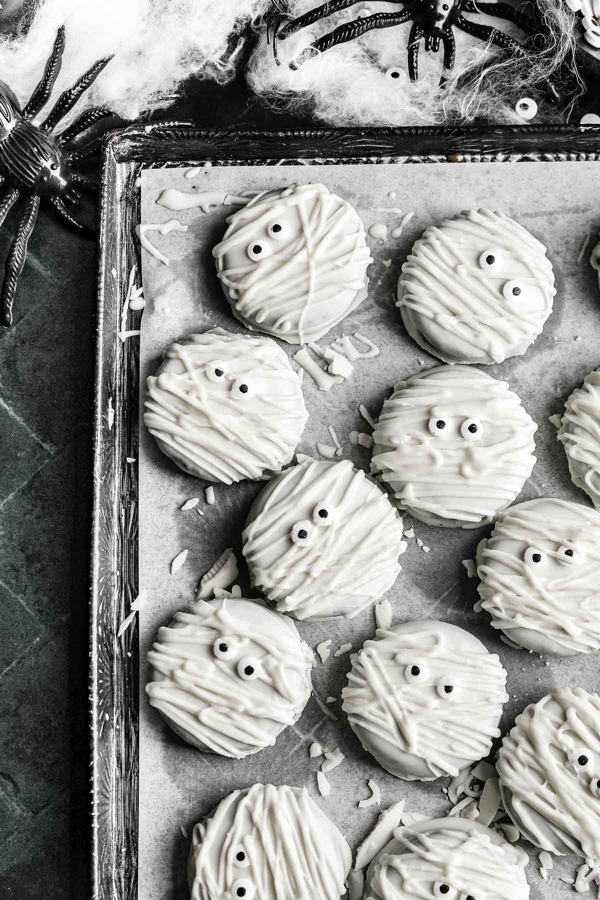 the mummy cookies on a sheet pan on top of parchment paper