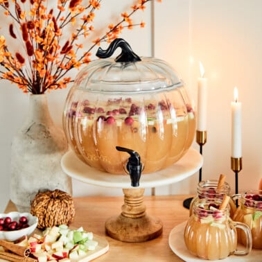 a pumpkin shaped punch bowl filled with caramel apple punch drink