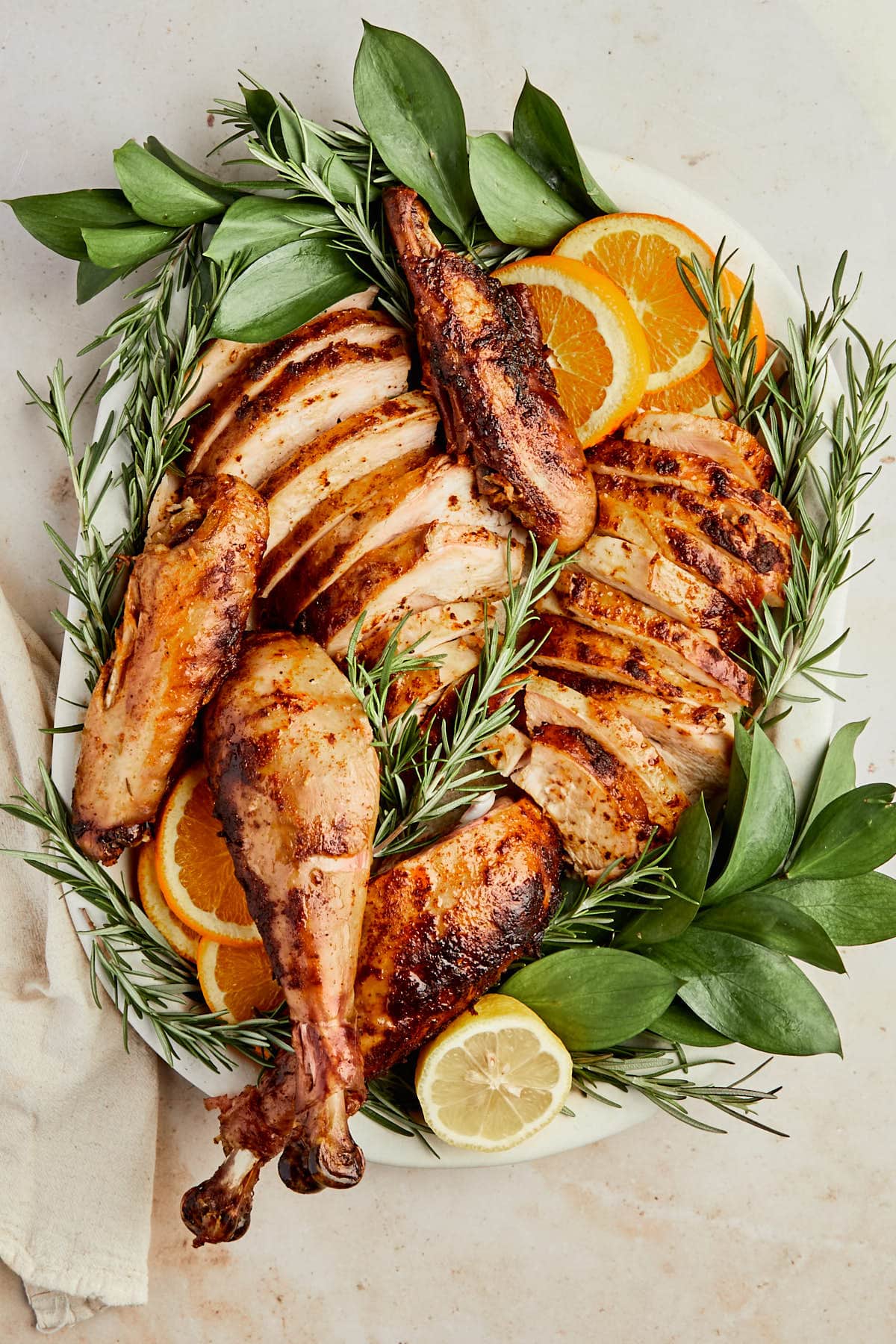 easy smoked turkey recipe carved on a plate with fresh herbs