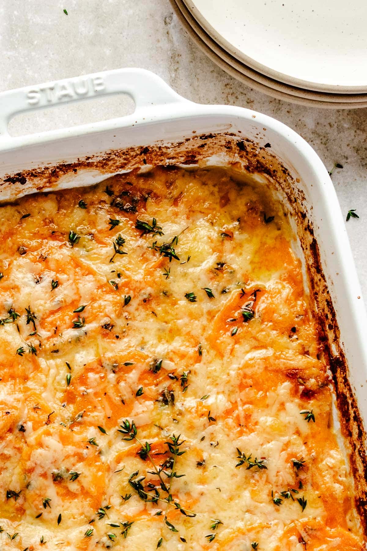 a sweet potato au gratin casserole up close to show the melted cheese 