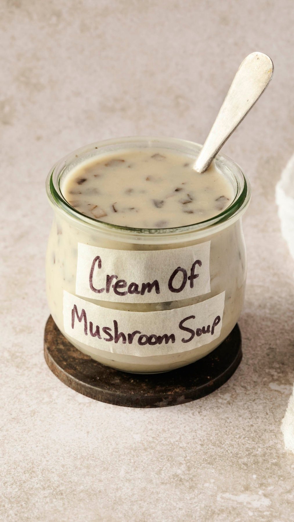 cream of mushroom soup substitute in a jar labeled and a spoon resting inside. 