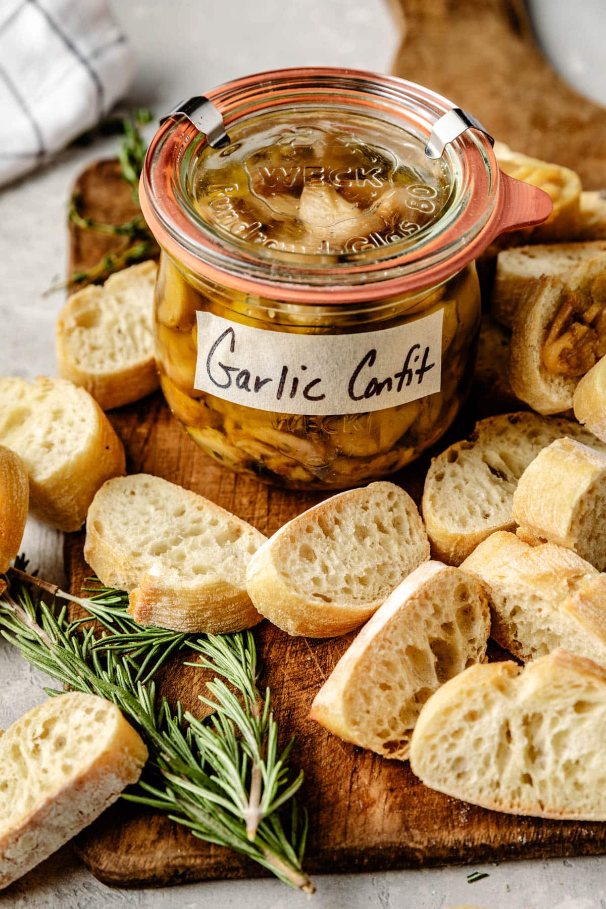 a jar of garlic confit surrounded by slices of bread