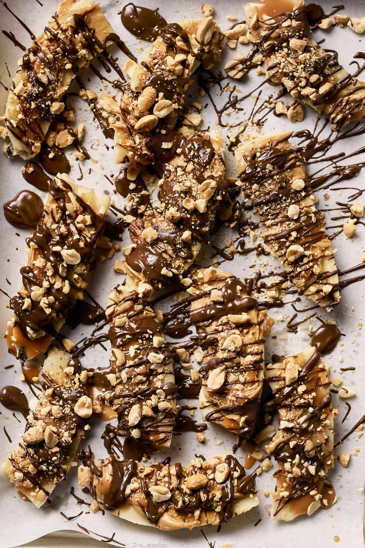 bananas covered in peanut butter and peanuts drizzled with chocolate 