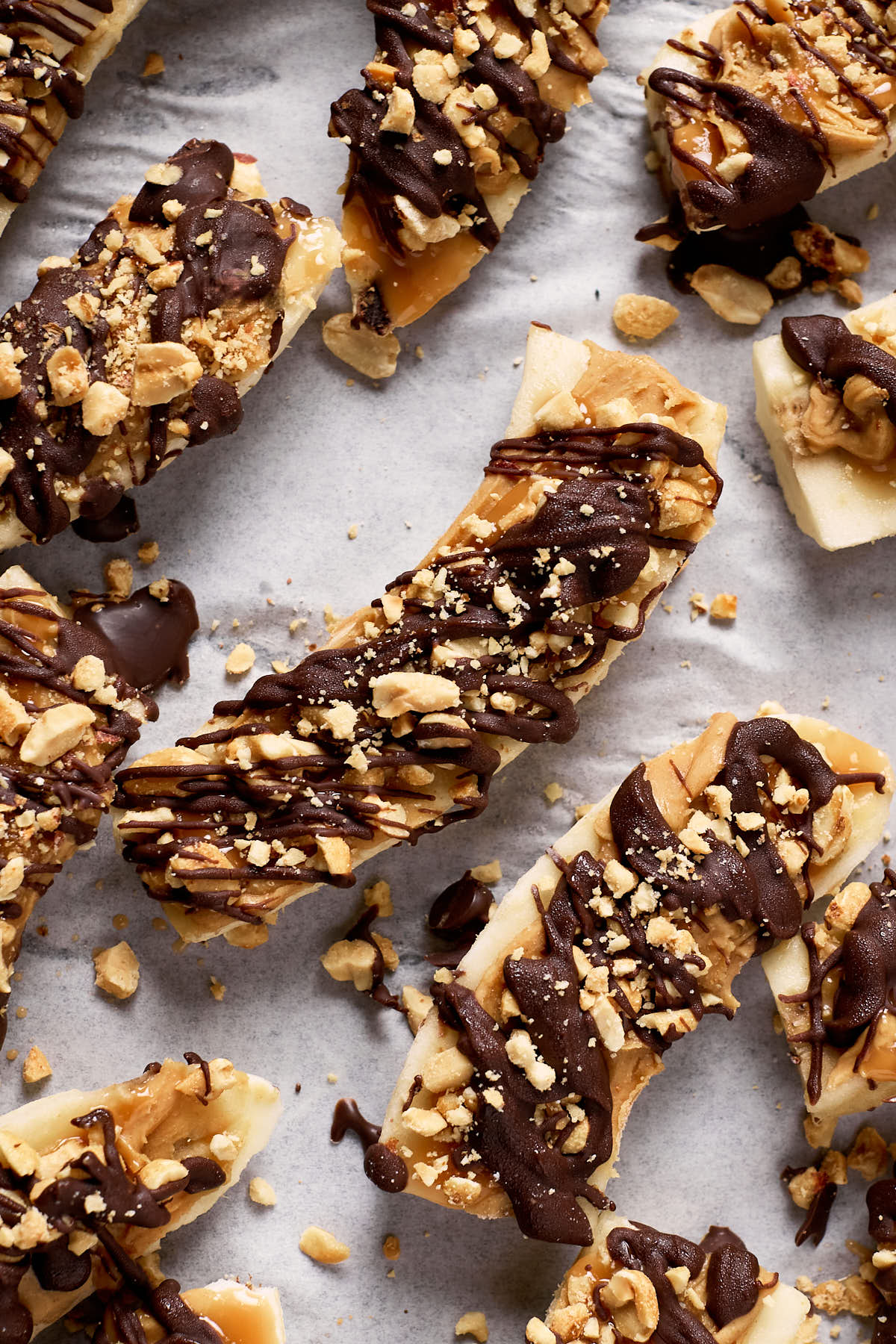 frozen banana snickers bars on parchment paper.