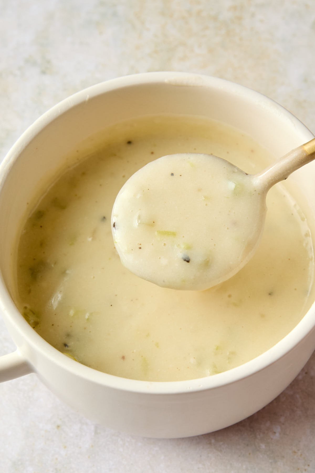 a spoonful of soup resting above a pot 