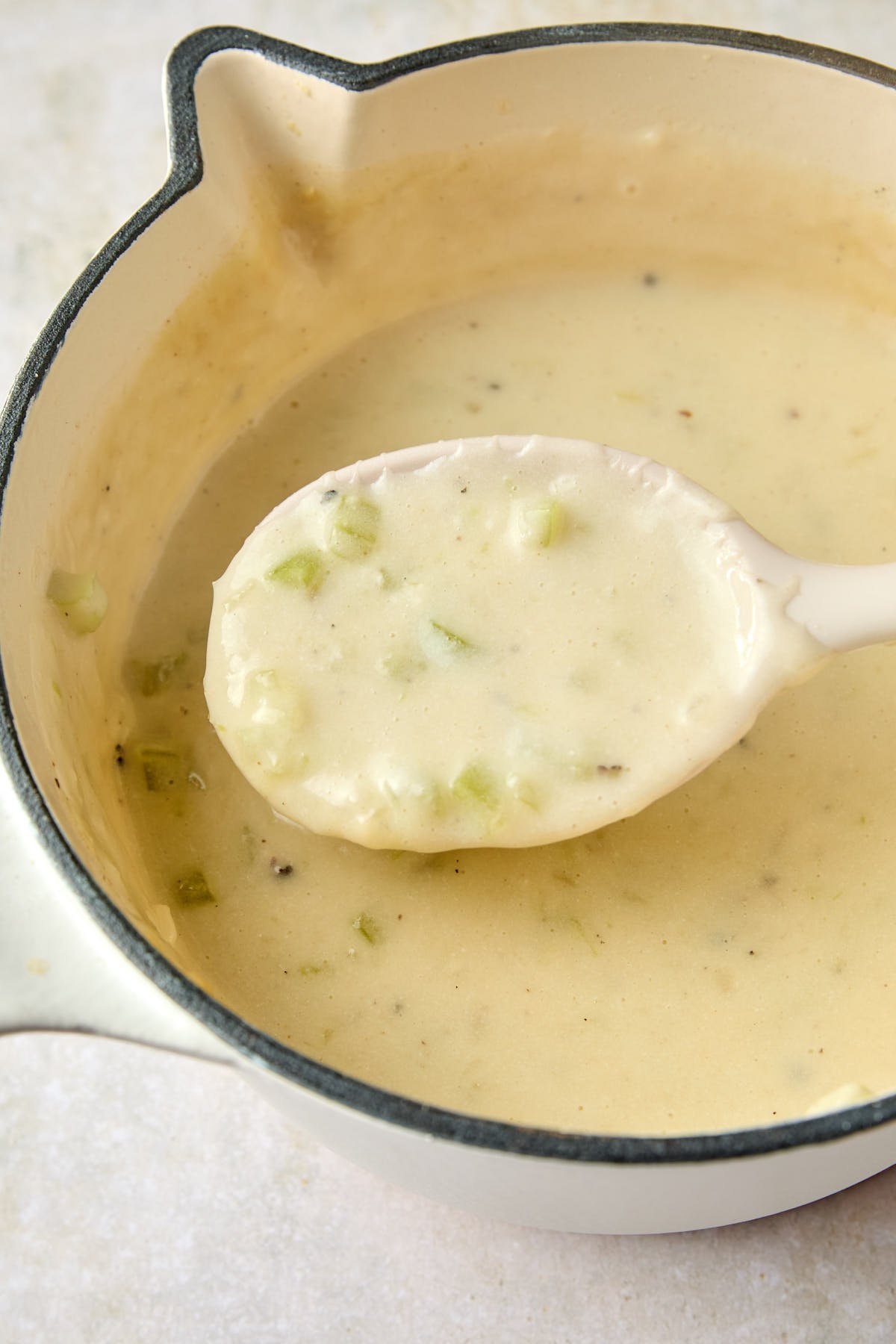 a spoon lifting soup out of a pot 