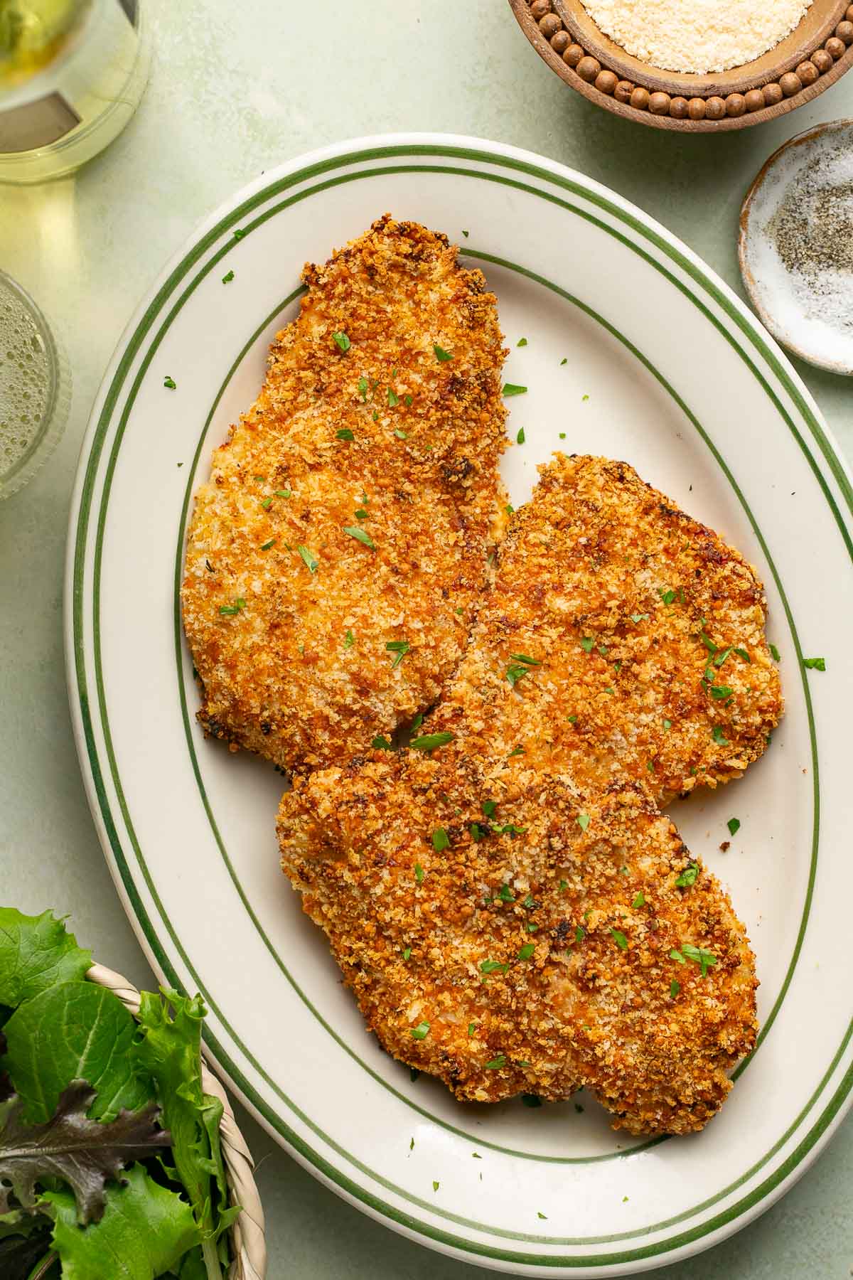 three air fryer chicken cutlets on a white serving plate