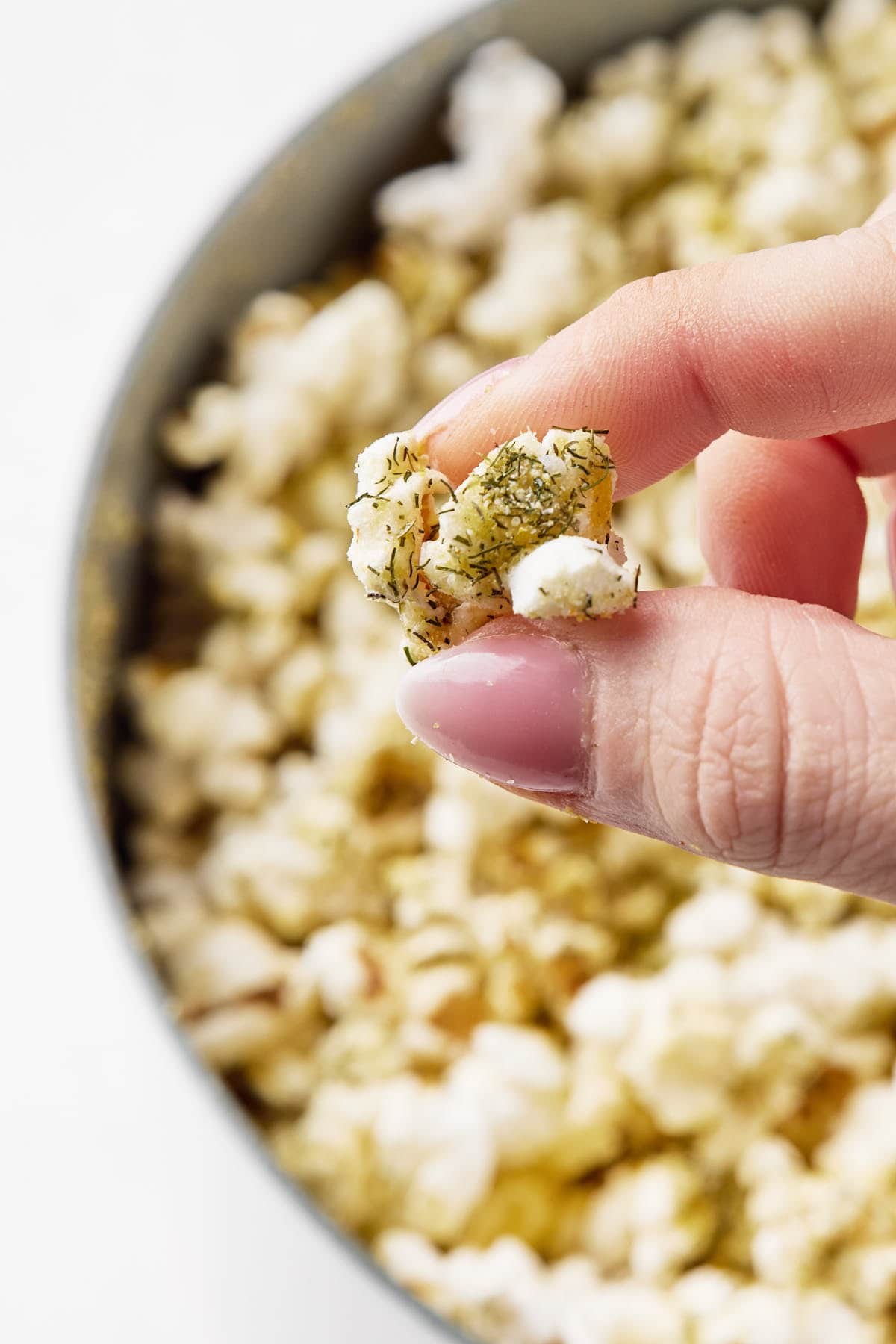 a hand holding one popcorn kernel