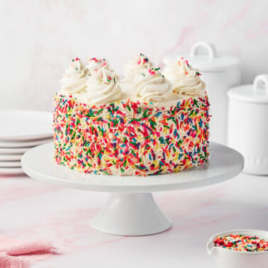 a gluten-free funfetti birthday cake on a white cake stand