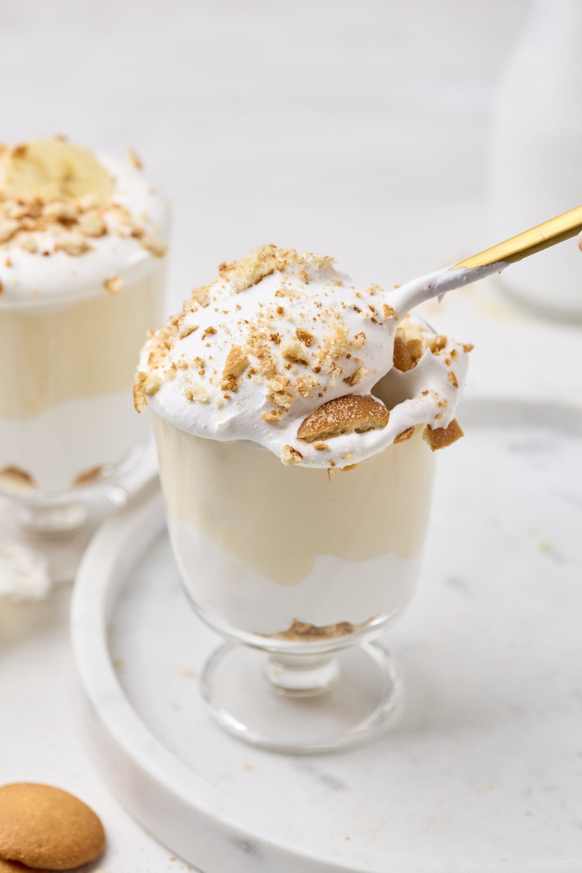 Protein Banana Pudding in a cup topped with whipped cream and crushed wafers