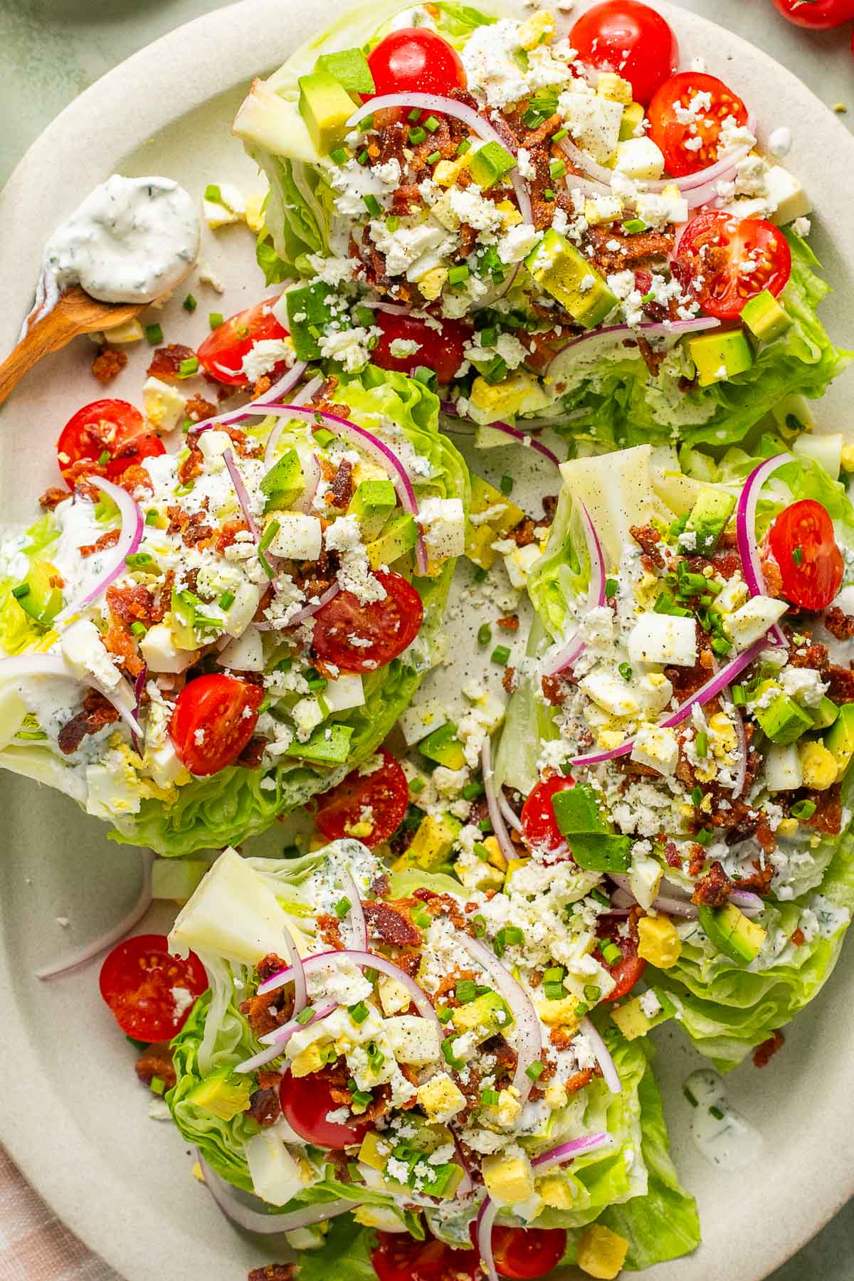 an overhead photo of a serving platter filled with garnished salad wedges. 