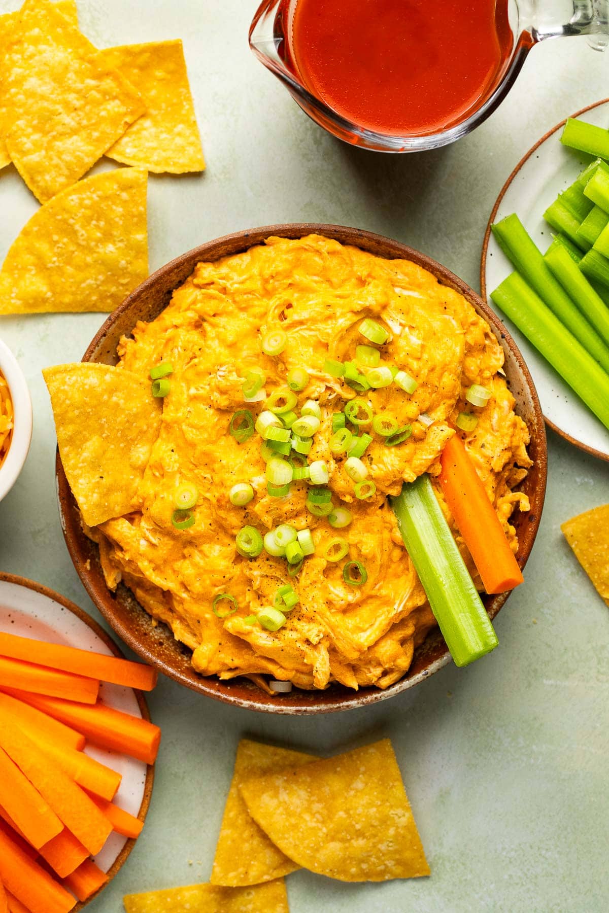 an overhead shot of dip in a bowl with veggies and chips