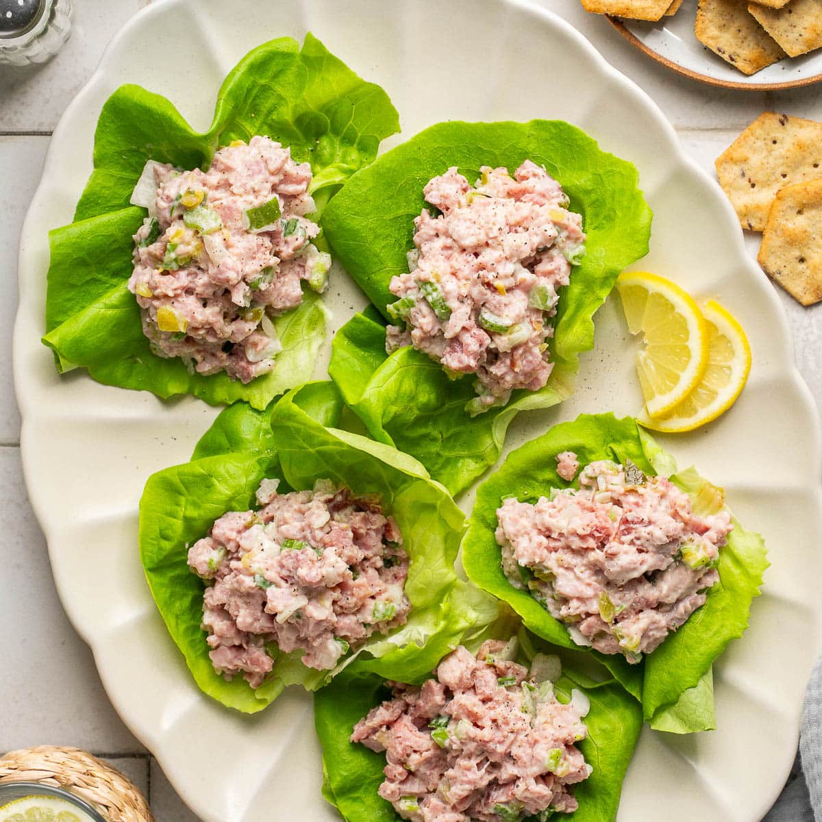 scoops of ham salad atop pieces of lettuce on a white platter