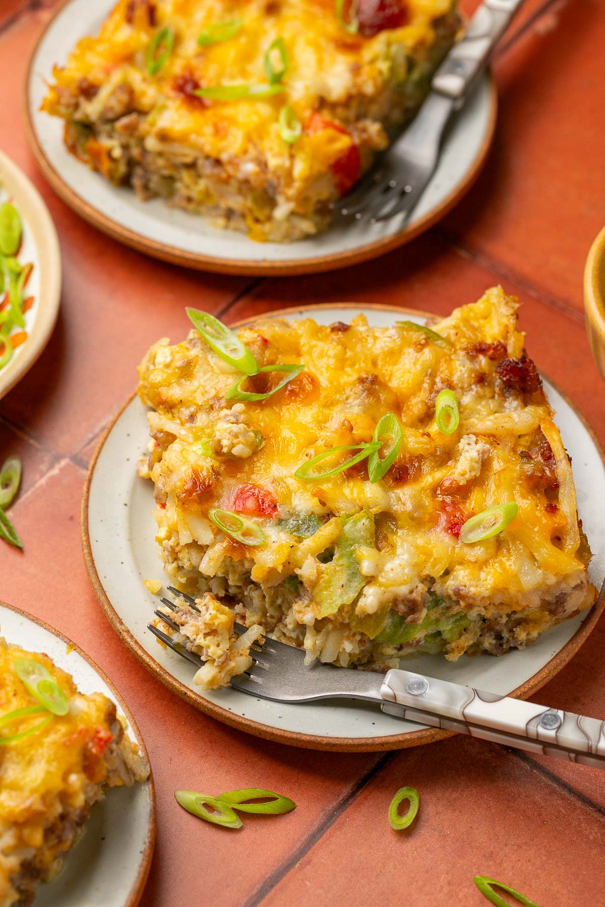 a slice of hash brown casserole on a white plate with a fork