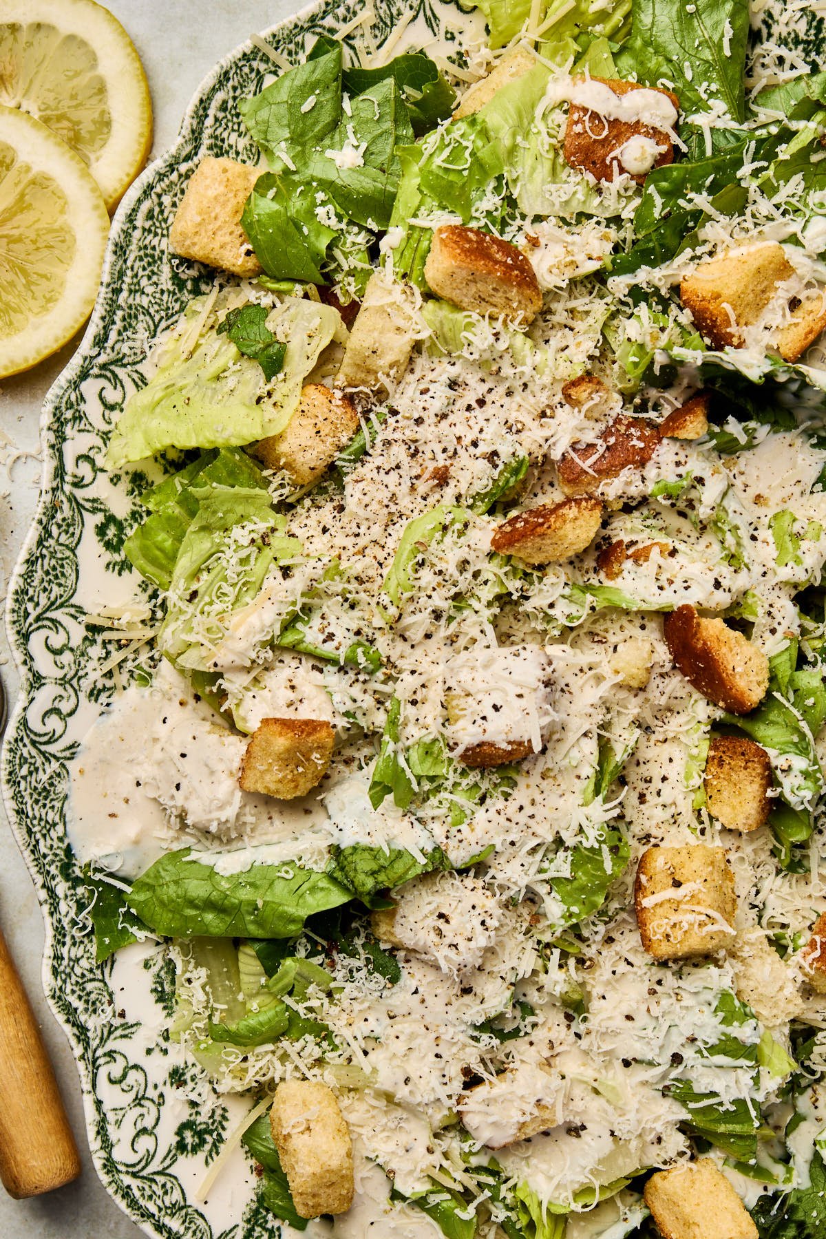 an up close shot of a salad topped with dressing and croutons