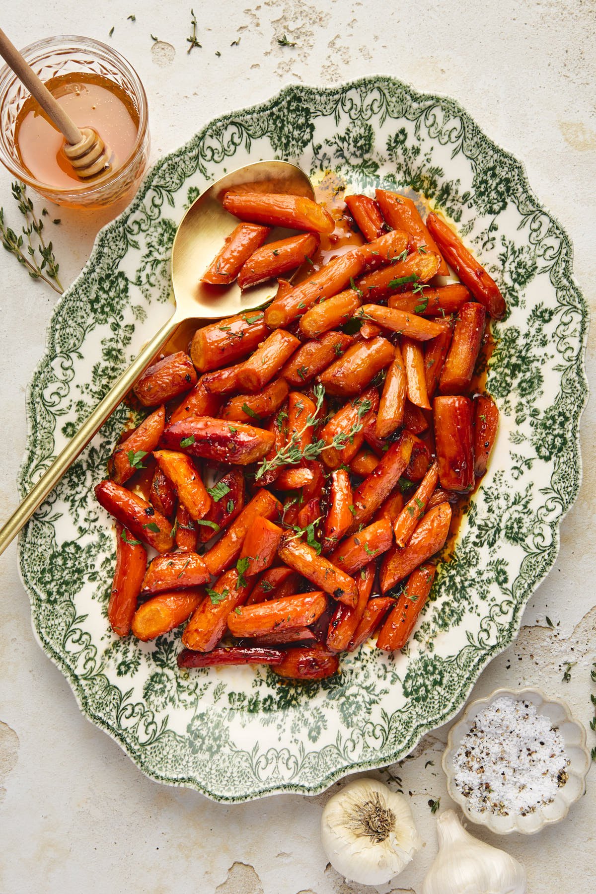 a platter filled with maple glazed carrots with a gold serving spoon 