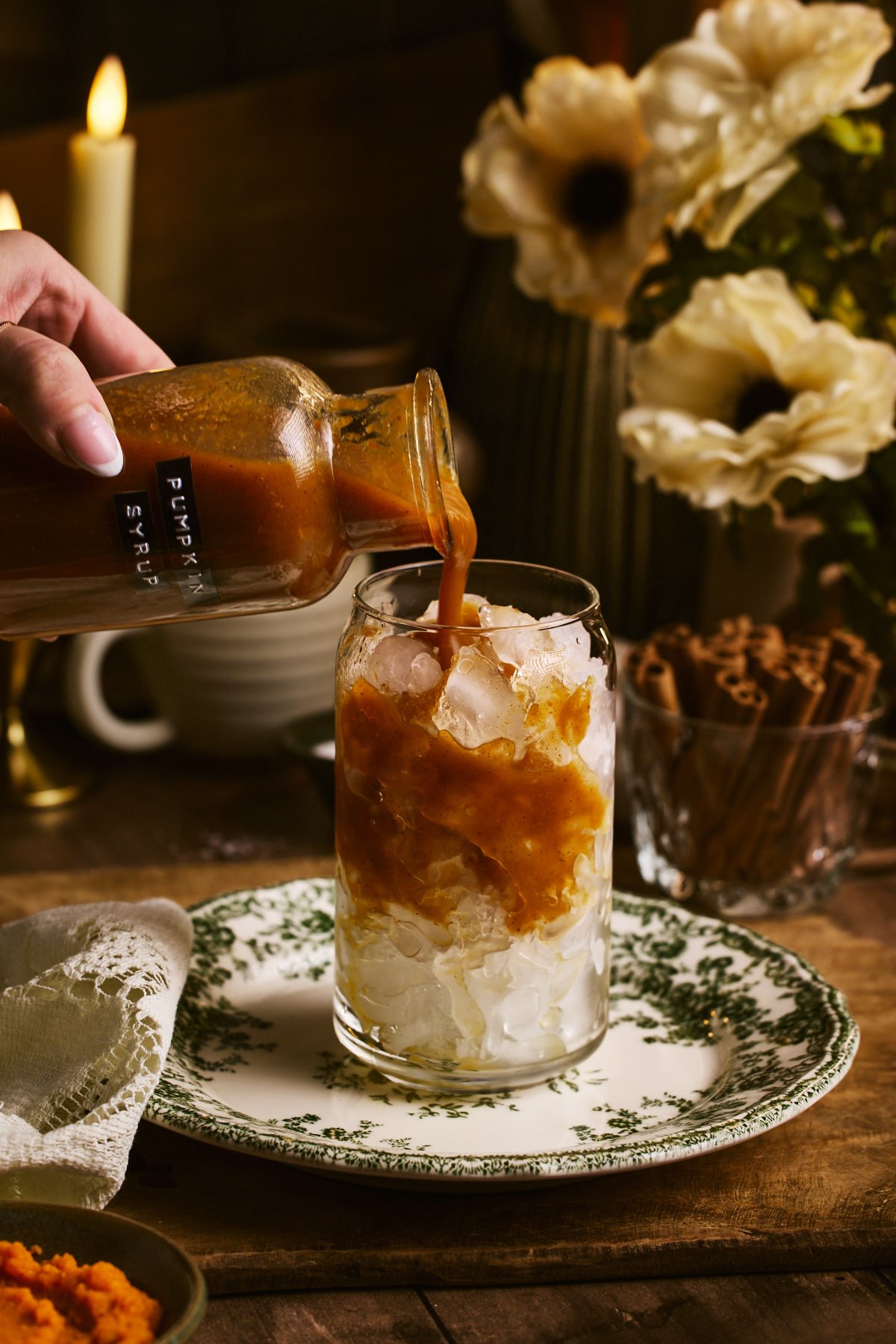 pouring the syrup in a glass of ice with coffee