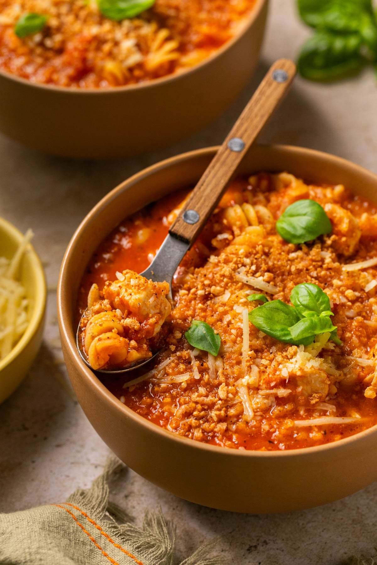 a bowl of chicken parmesan soup topped with bread crumbs