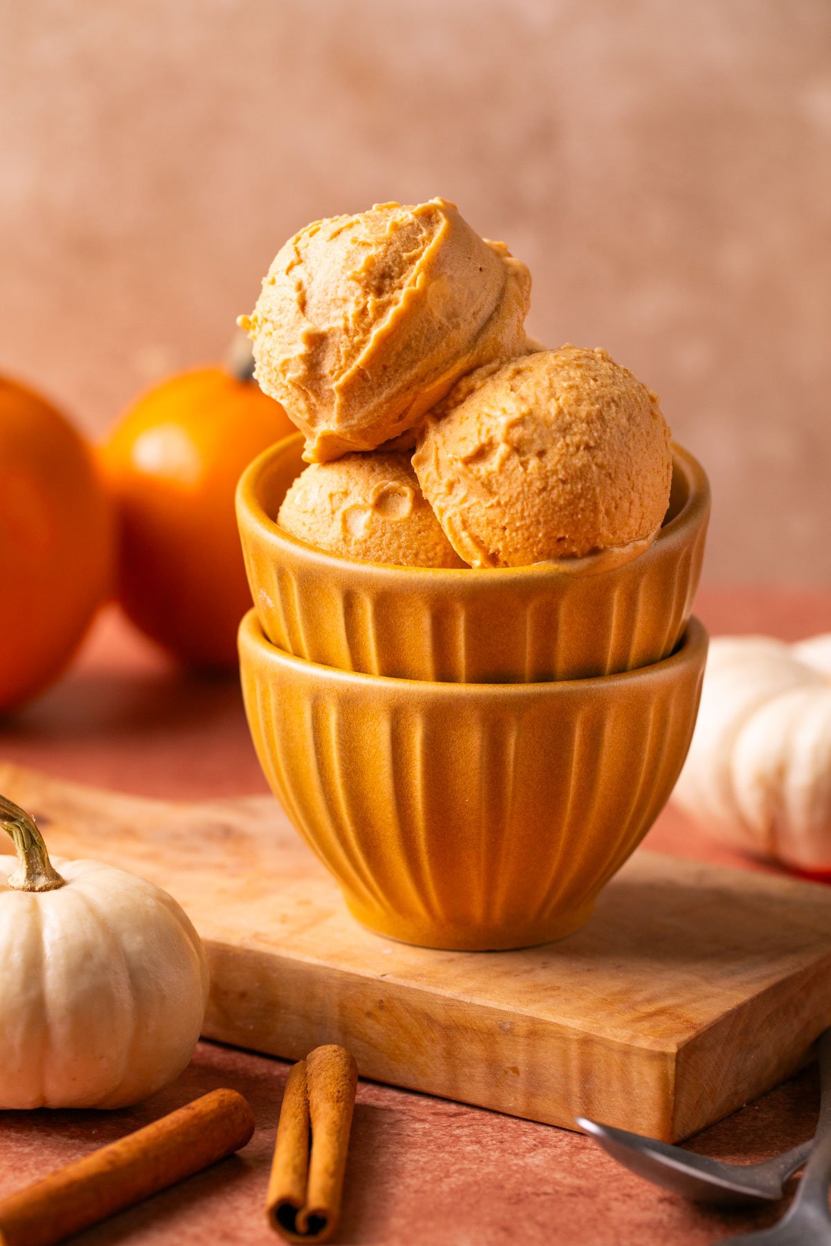 three scoops of pumpkin ice cream in a yellow bowl 