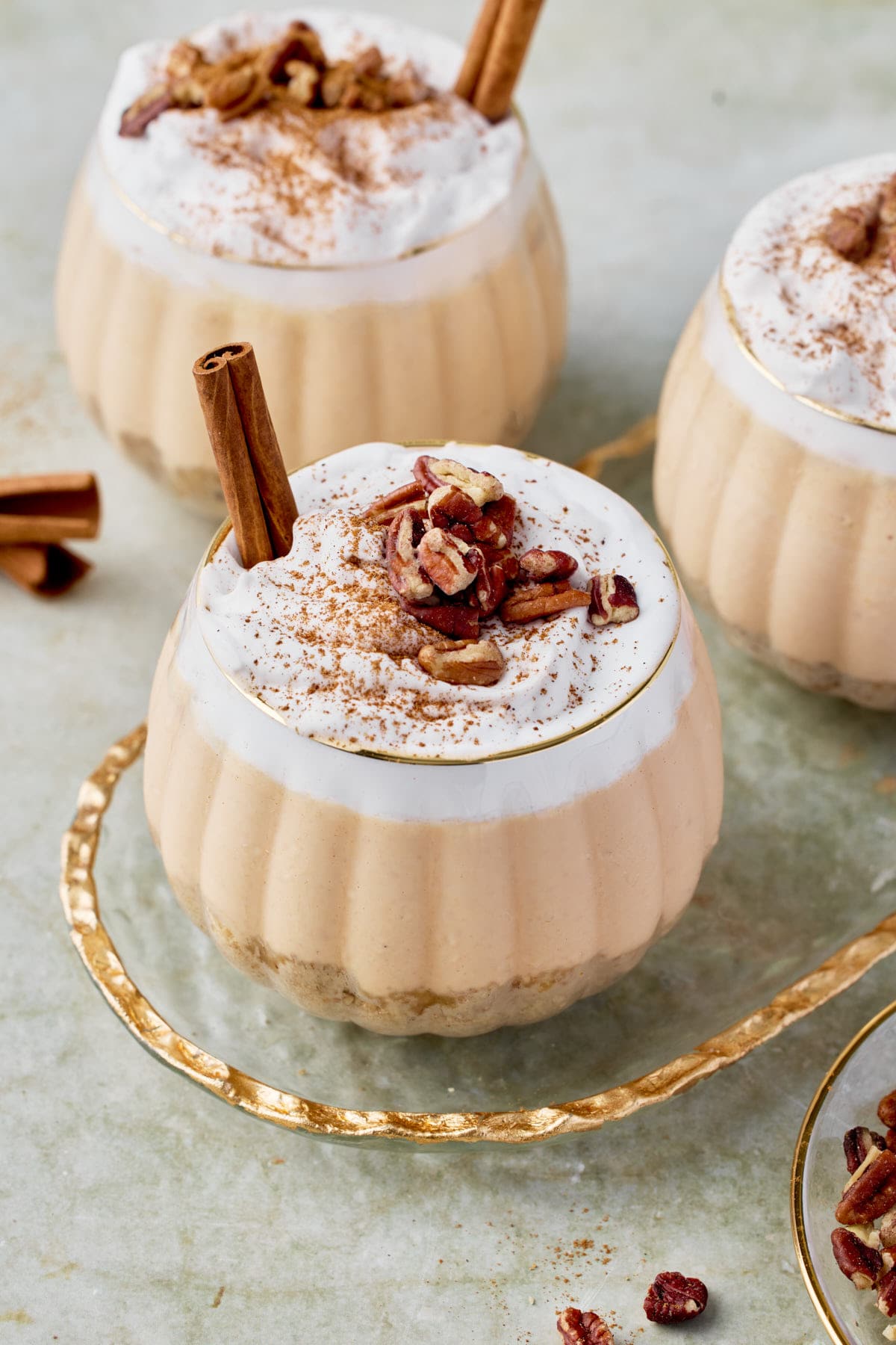 a top view of no-bake pumpkin cheesecake jars topped with whipped cream and nuts 