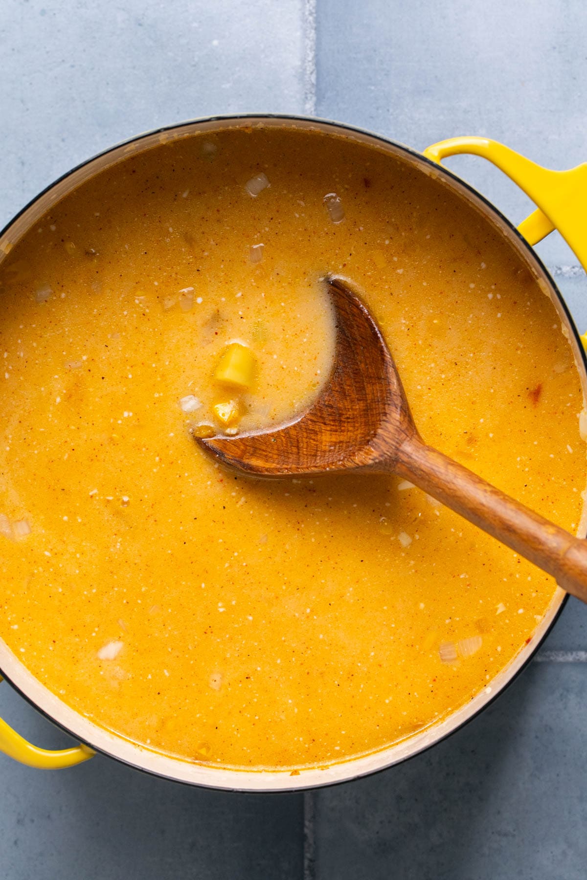 a soup pot filled with creamy orange soup