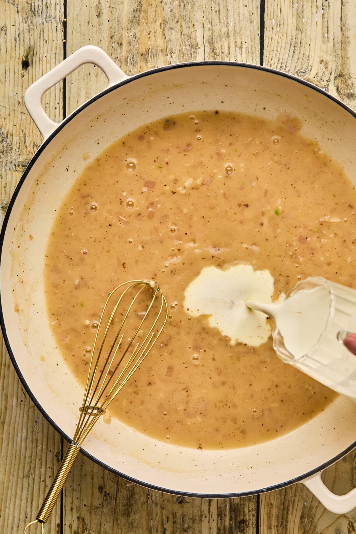 pouring cream into a broth 