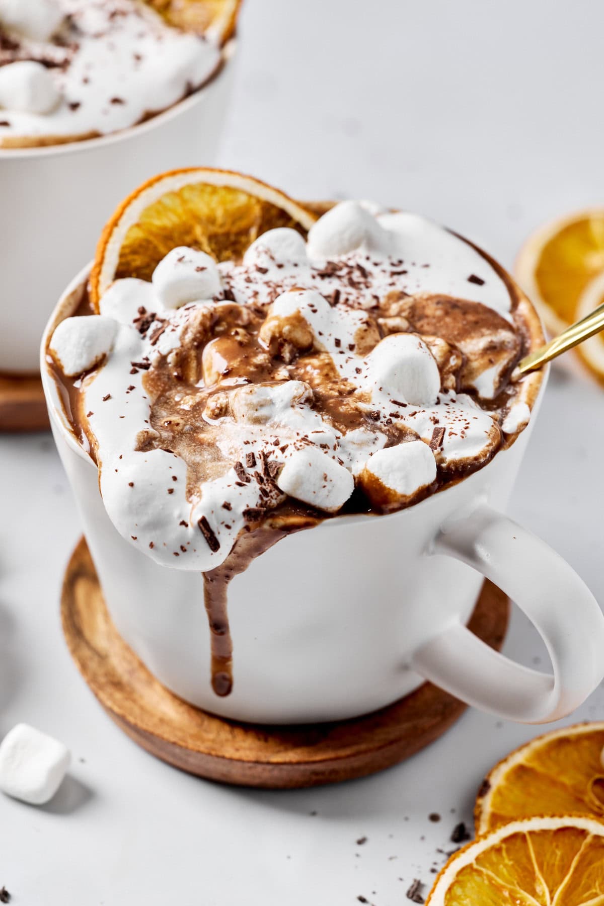 a cup of dairy-free hot chocolate topped with marshmallows and whipped cream. 