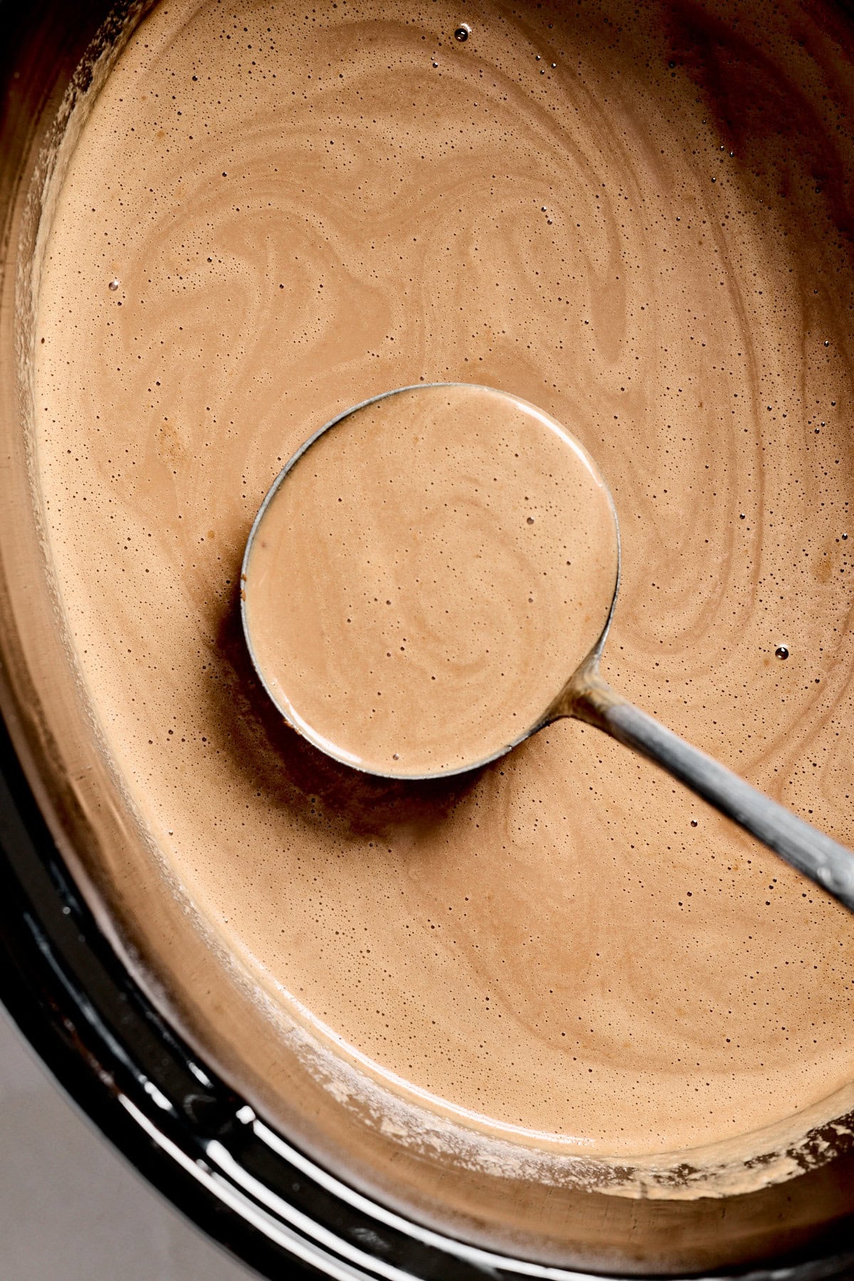 a ladle scooping out a serving of hot chocolate. 