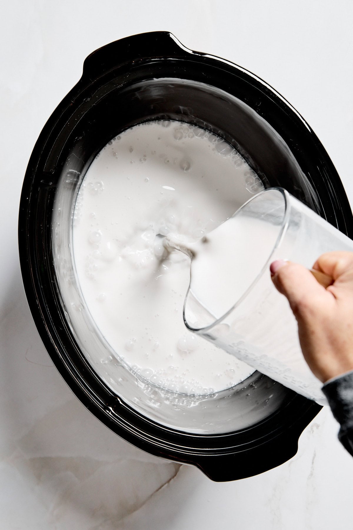 pouring non-dairy milk into a crockpot