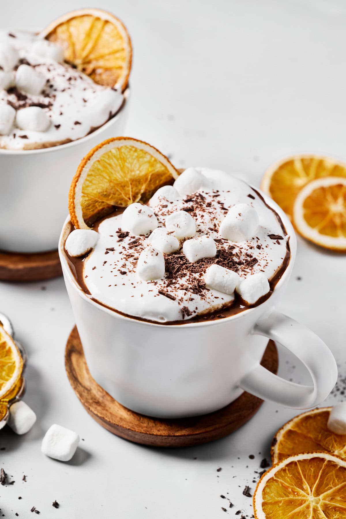 dairy-free hot chocolate in a mug topped with whipped cream, marshmallows, and chocolate shavings. 