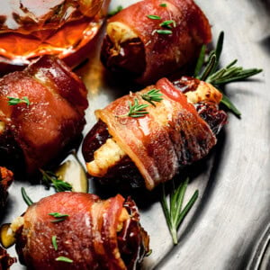 stuffed dates wrapped in bacon and topped with rosemary