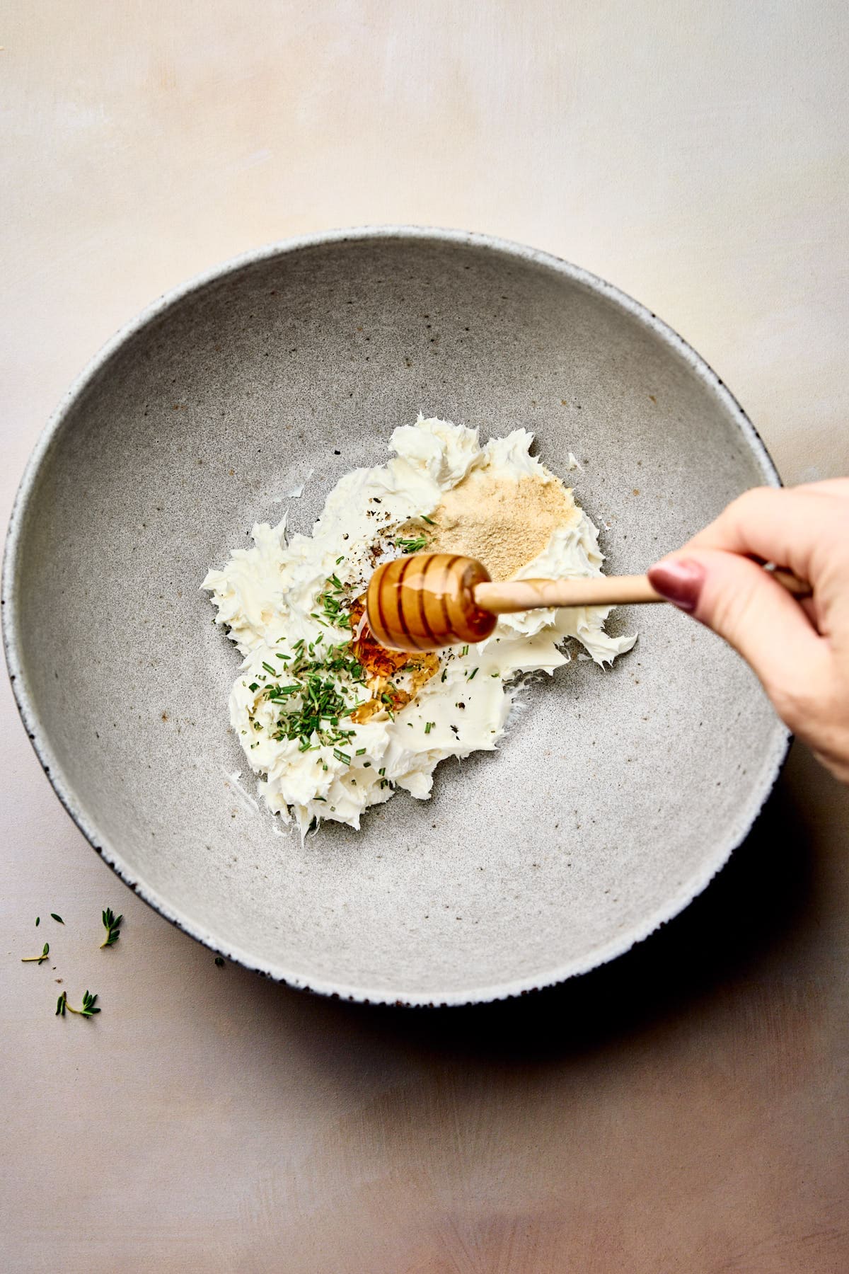 drizzling honey on top of a cream cheese mixture