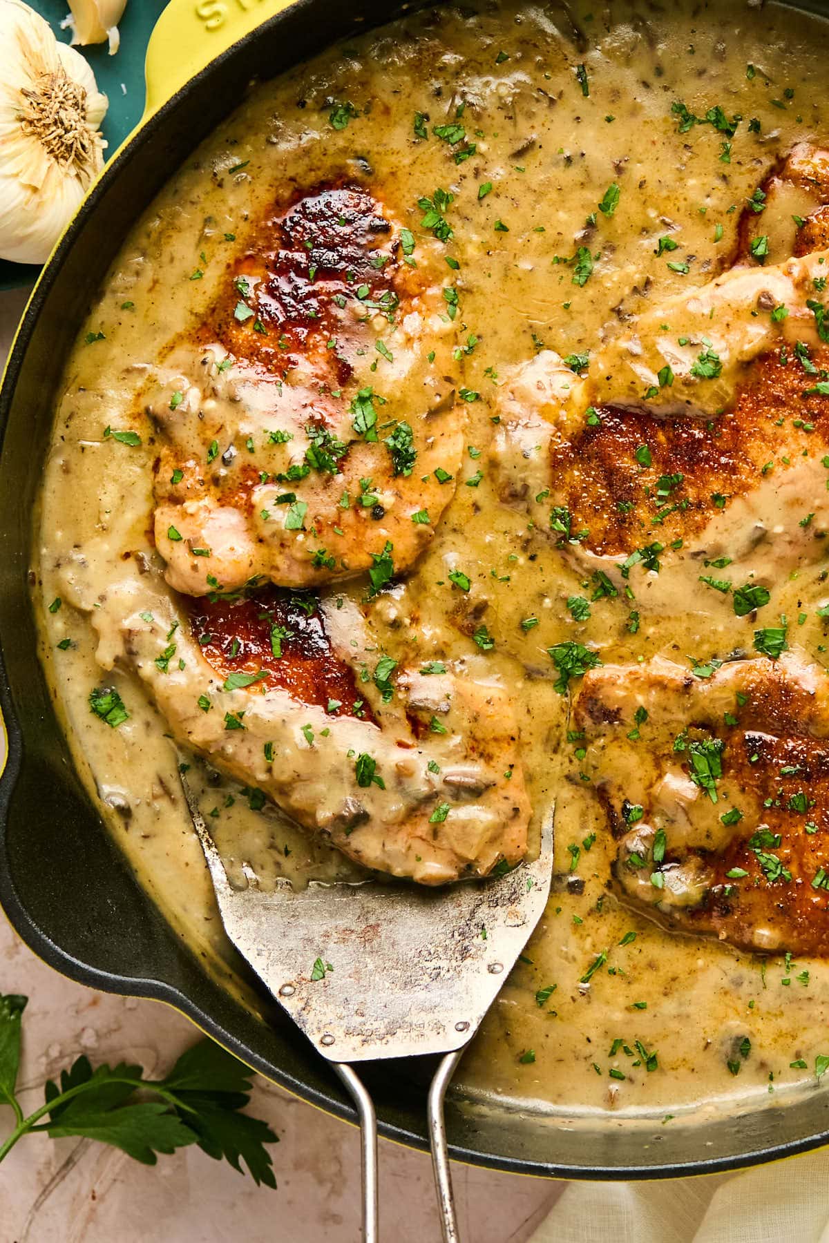 a spatula lifting a piece of meat out of a pan. 