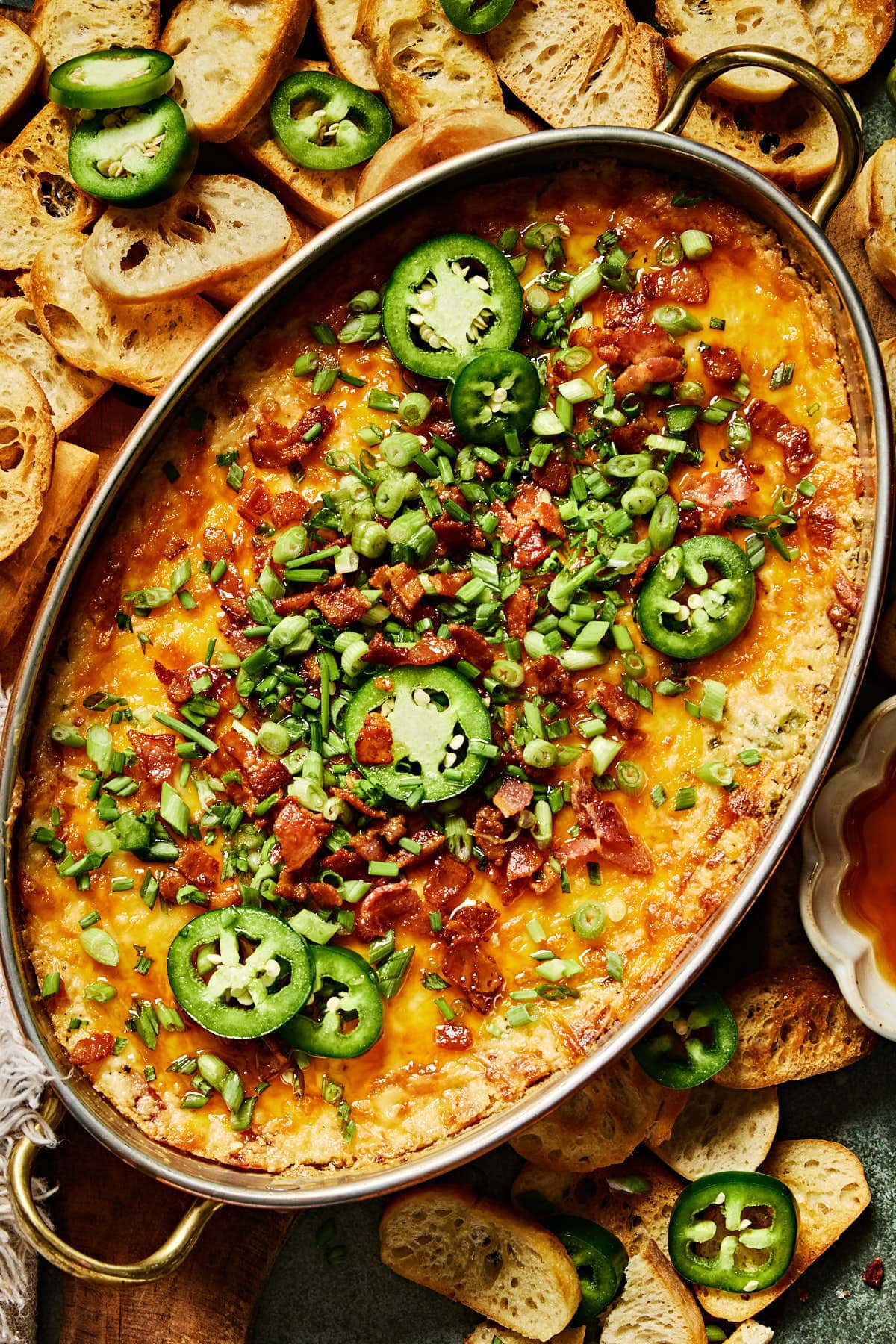 baked hot honey jalapeno popper dip topped with green onions, jalapeno, and bacon. 