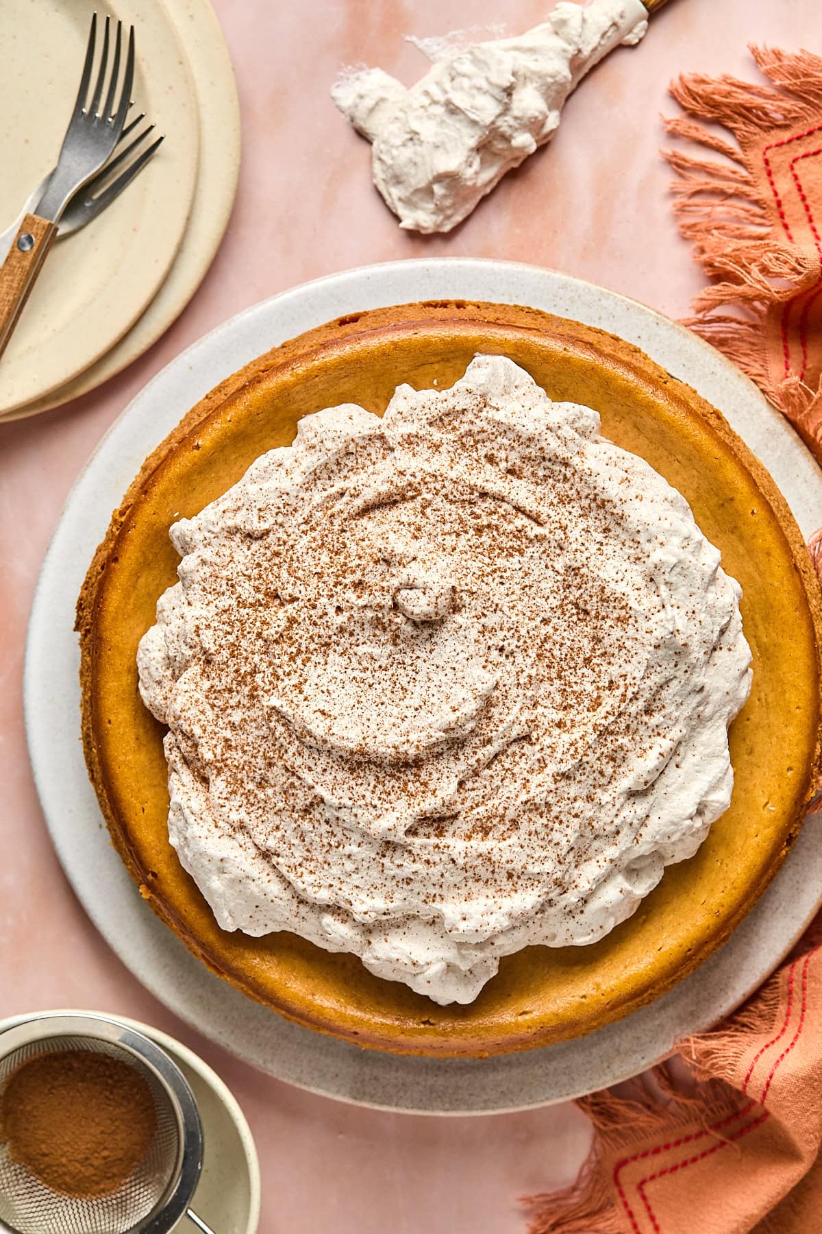 a gluten-free pumpkin cheesecake topped with whipped cream and spices. 