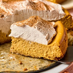 a slice of gluten free pumpkin cheesecake topped with whipped cream