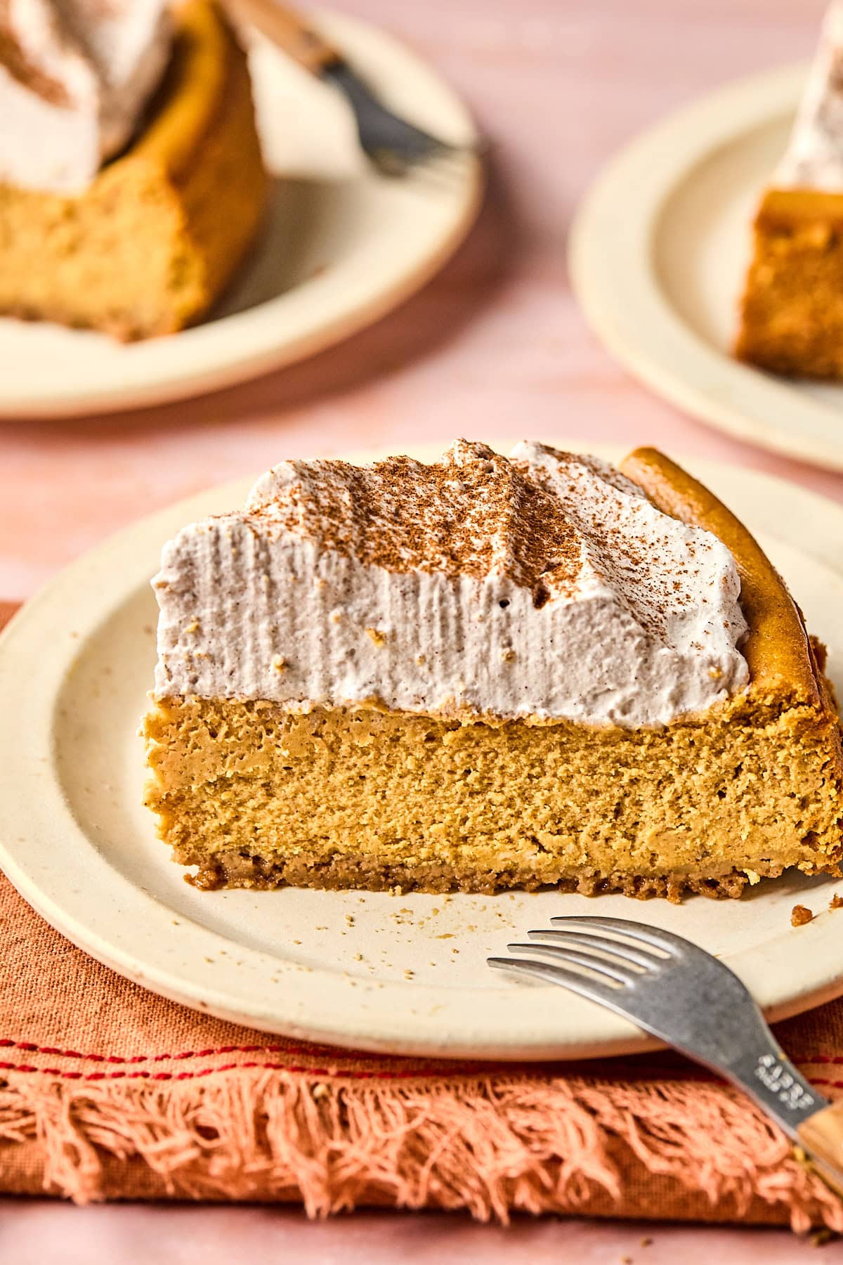 a slice of gluten-free cheesecake on a white plate with a fork. 