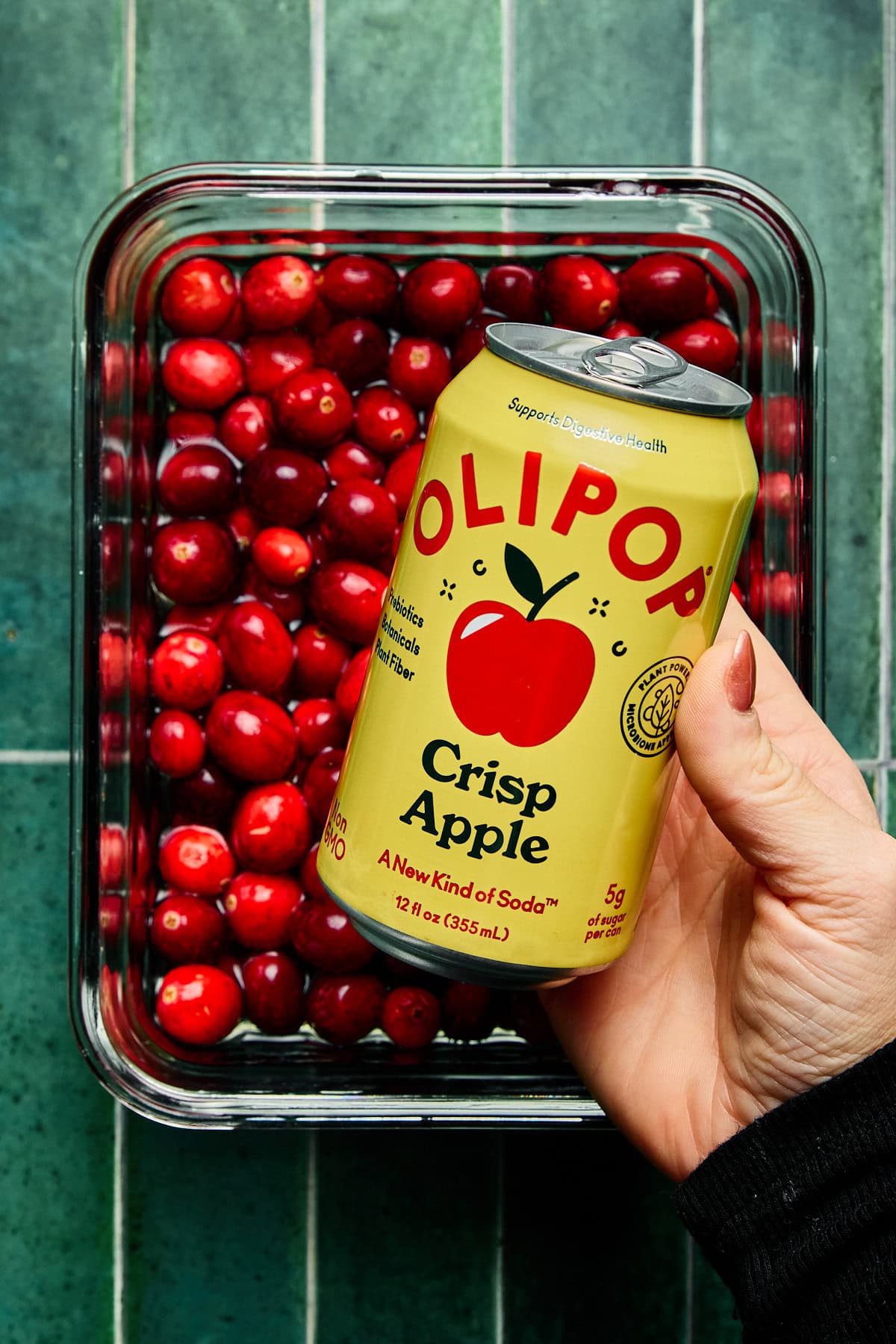 a can of olipop soda over a tray of cranberries