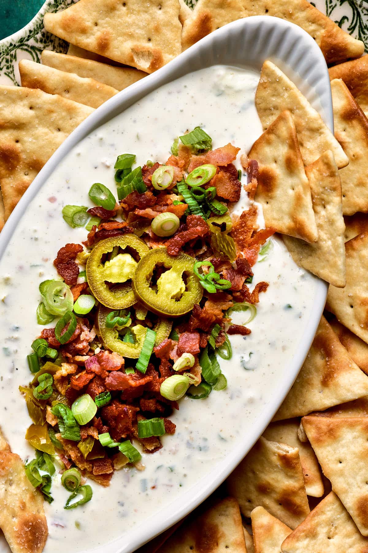 jalapeno ranch dip in a white serving dish next to crackers 