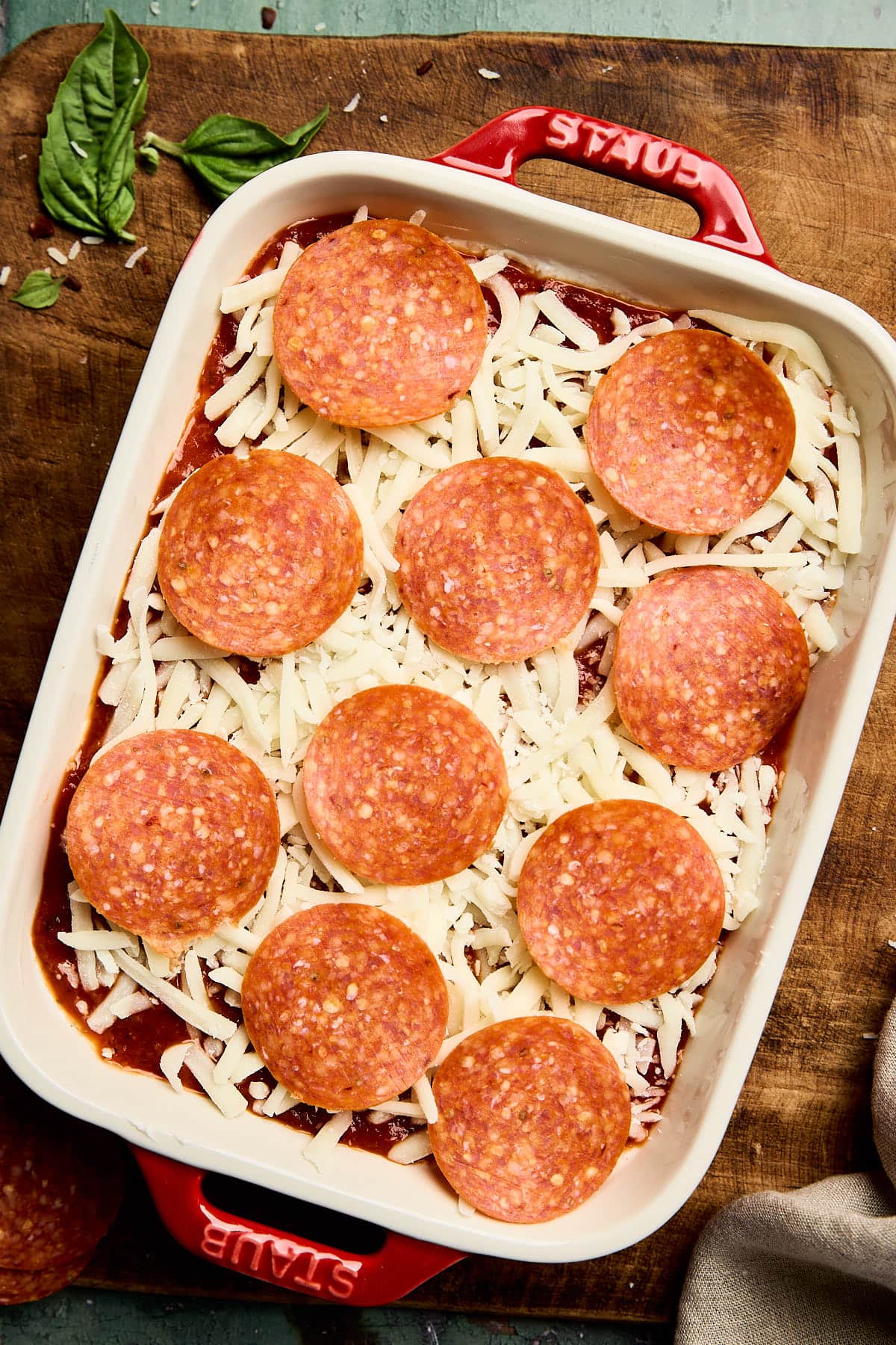 the dip topped with shredded cheese and pepperoni in a baking dish