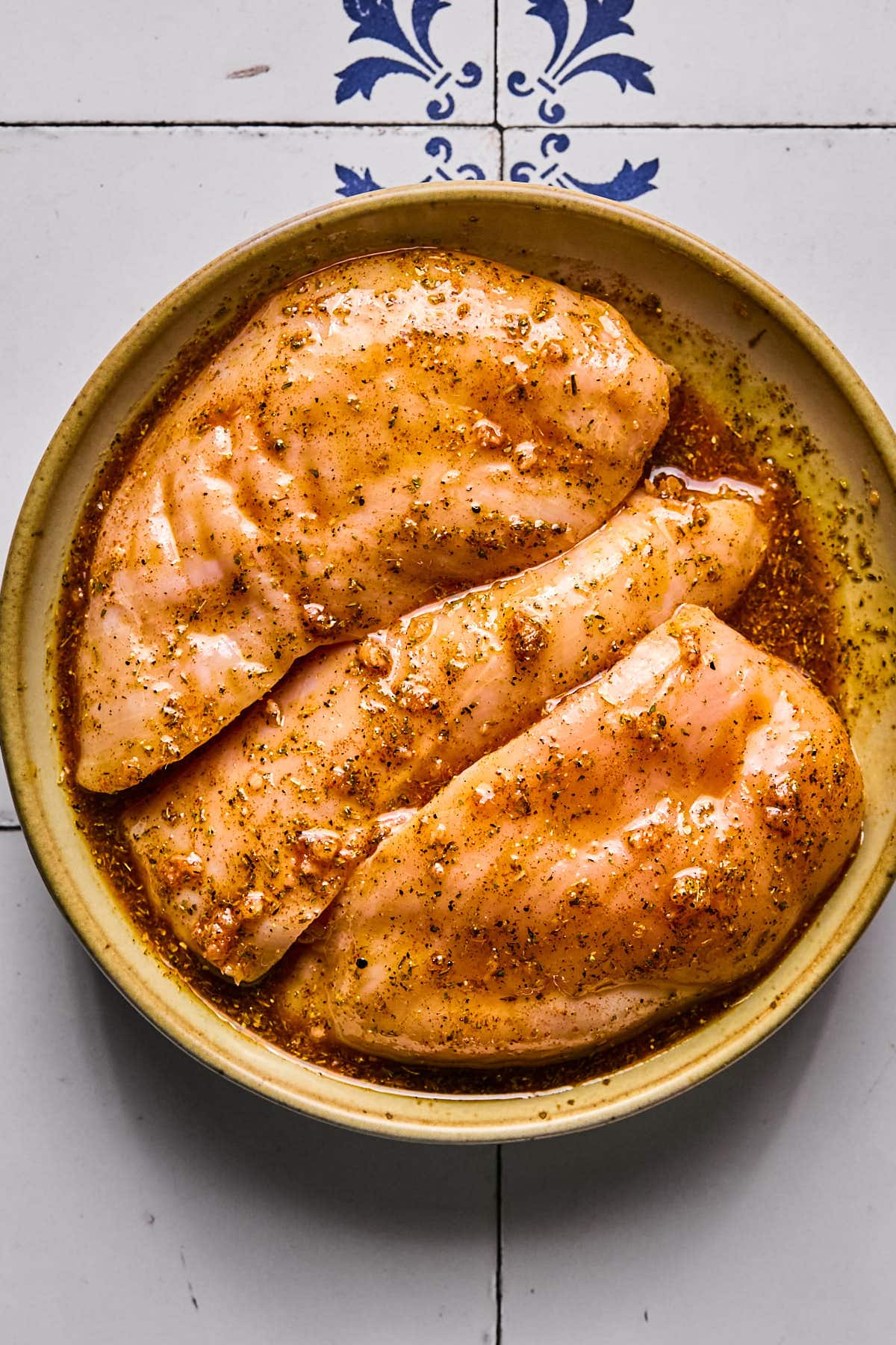 chicken marinating in a bowl 