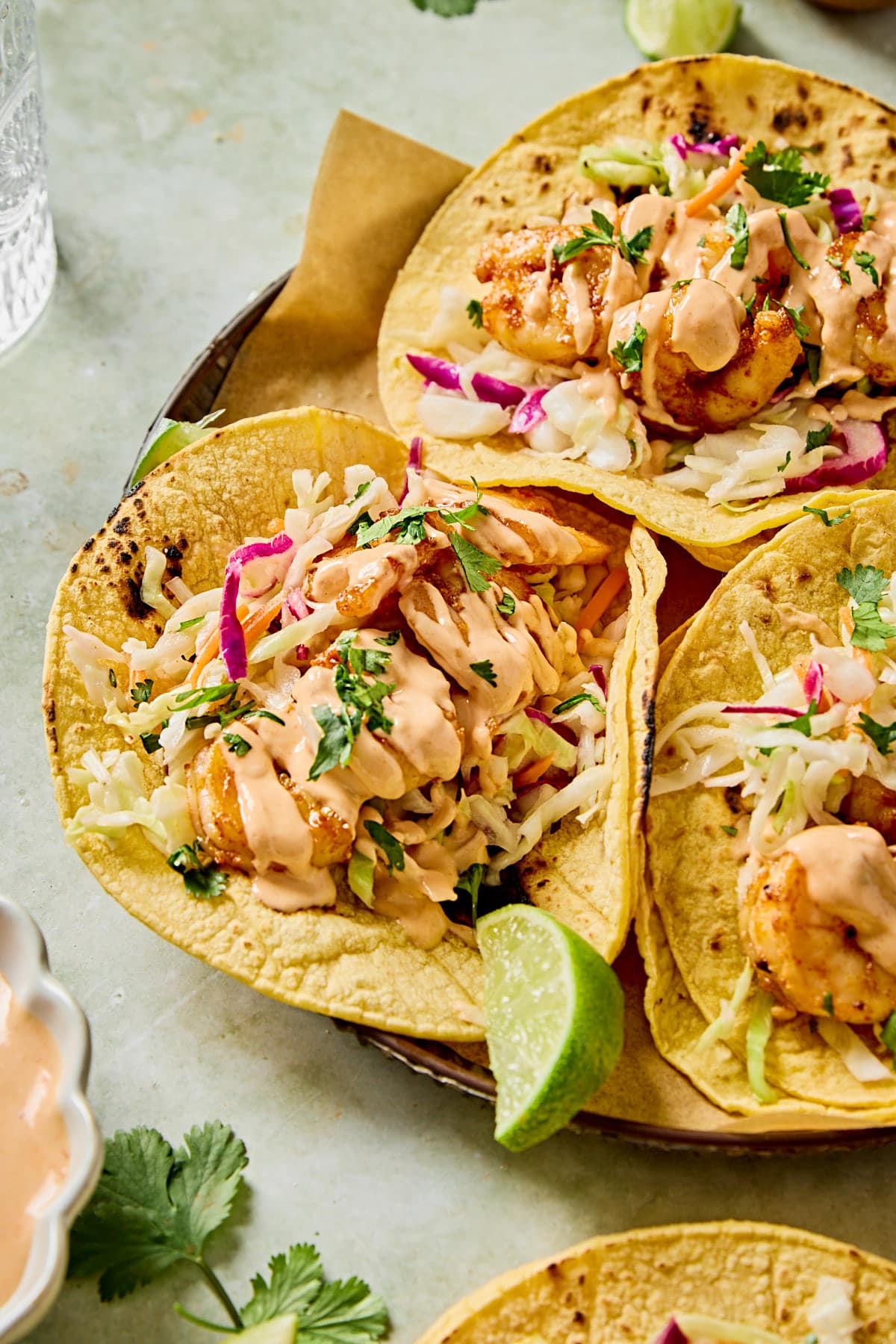 a close up picture of three shrimp tacos on a plate